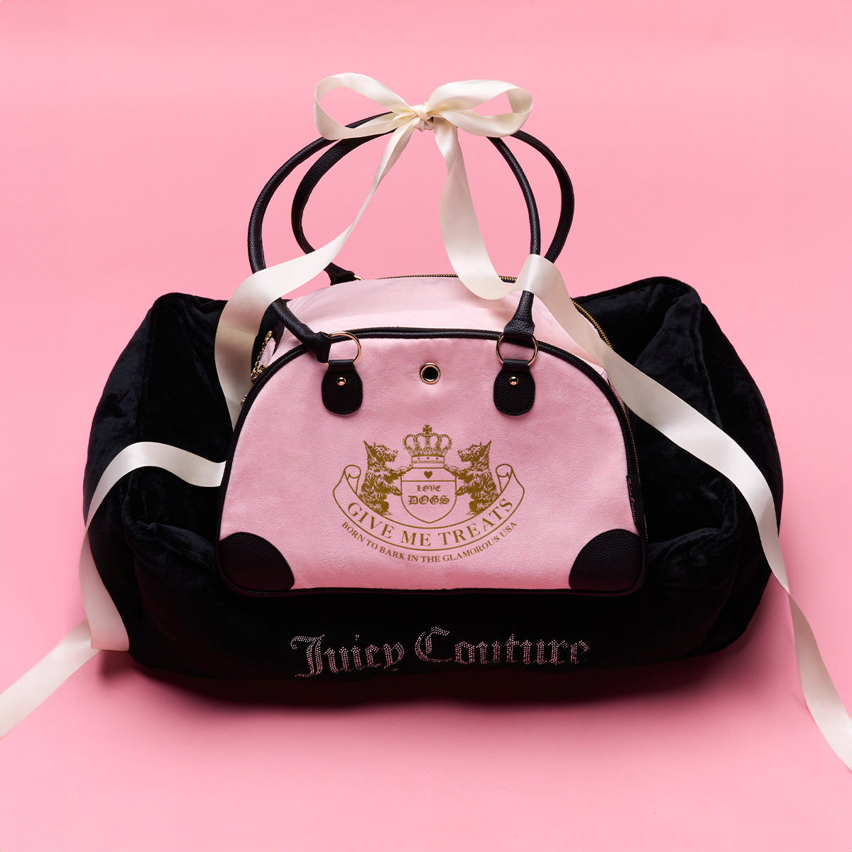 Pink pet bag with black accents and Juicy Couture branding on a pink background