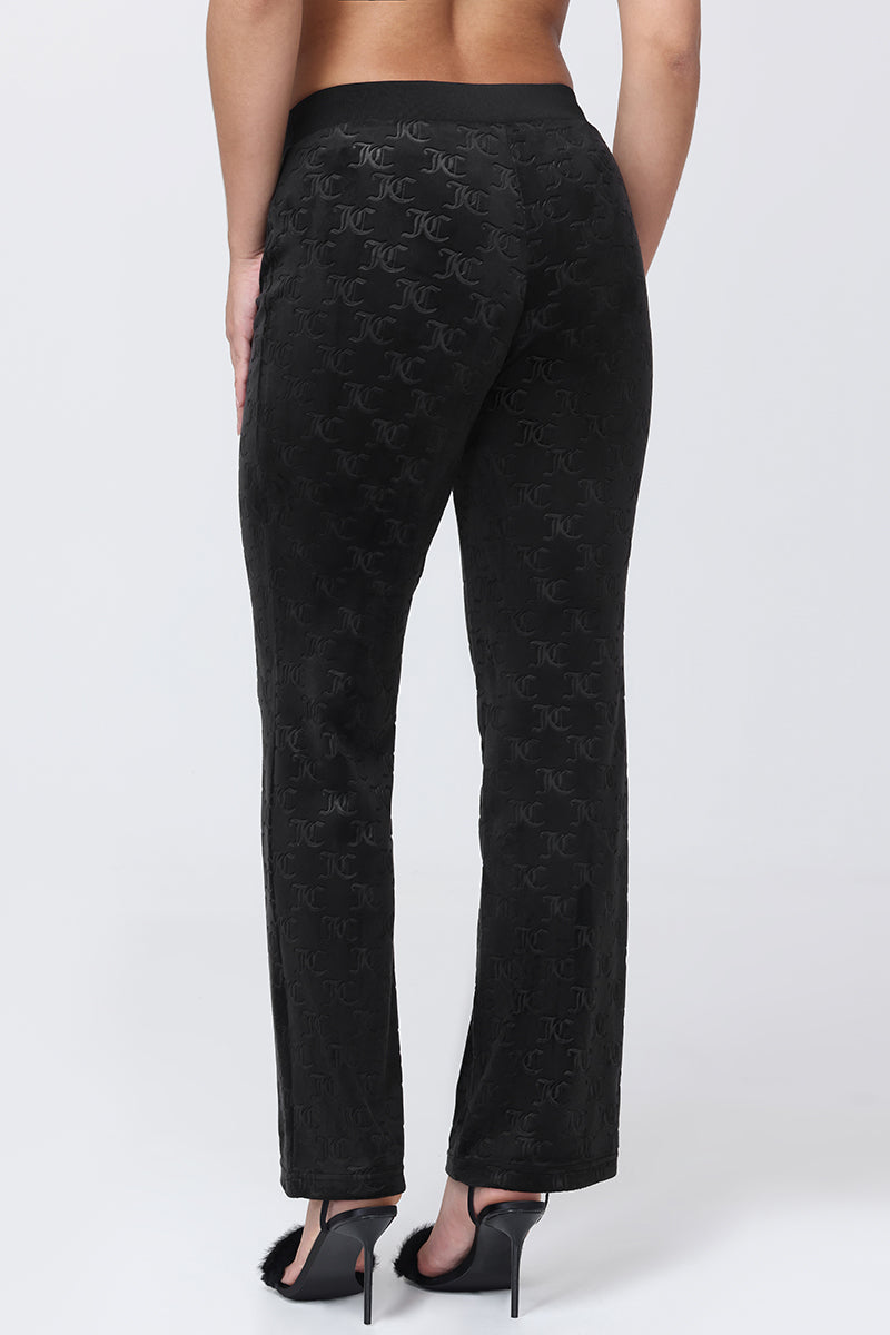 Back view of black Embossed Velour Track Pants in plush velour featuring an all-over embossed monogram pattern.