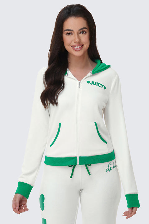 A woman with long dark hair smiles while wearing the Contrast Trim Logo Hoodie in white with green accents and "JUICY" on the chest, paired with matching white and green sweatpants. She stands against a plain light background.