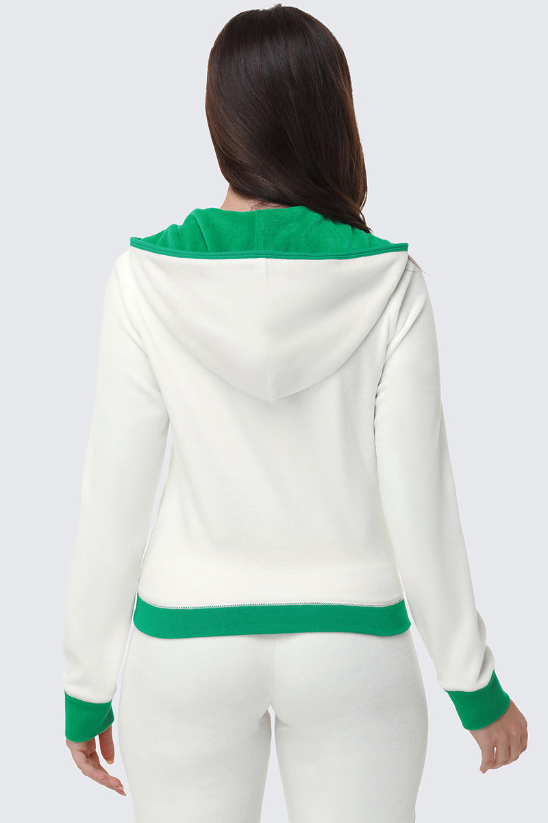 A woman with long brown hair is shown from the back wearing a white Contrast Trim Logo Hoodie with green accents on the hood, cuffs, and waistband. Her hoodie and pants look like a coordinated set.