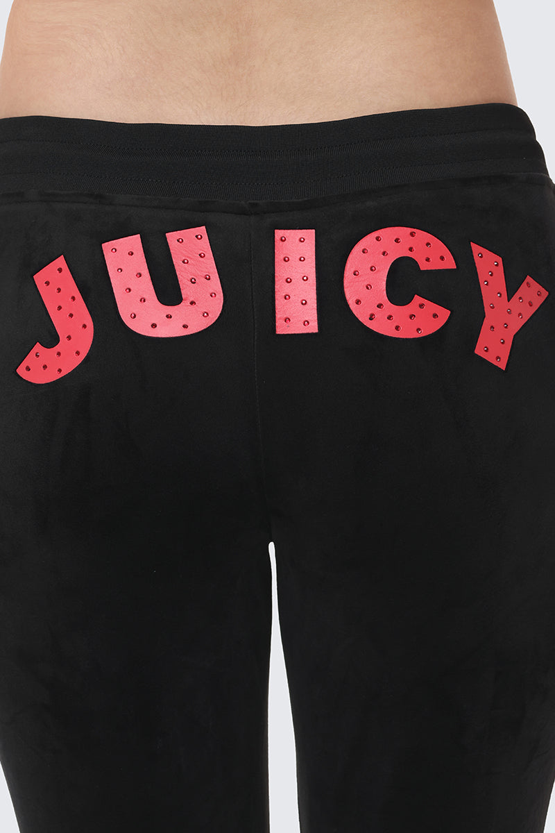 A close-up of the back of the Cherry Bling Velour Jogger shows a bold red Juicy graphic with small studs across the top.