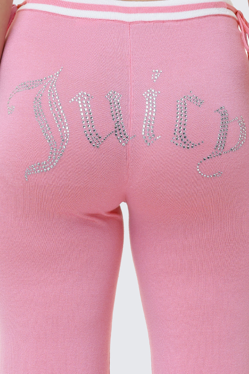 A close-up of the back of the Big Bling Wide Leg Pants shows pink velour fabric, a sparkling rhinestone Juicy logo across the seat, and a bold contrast striped waistband.