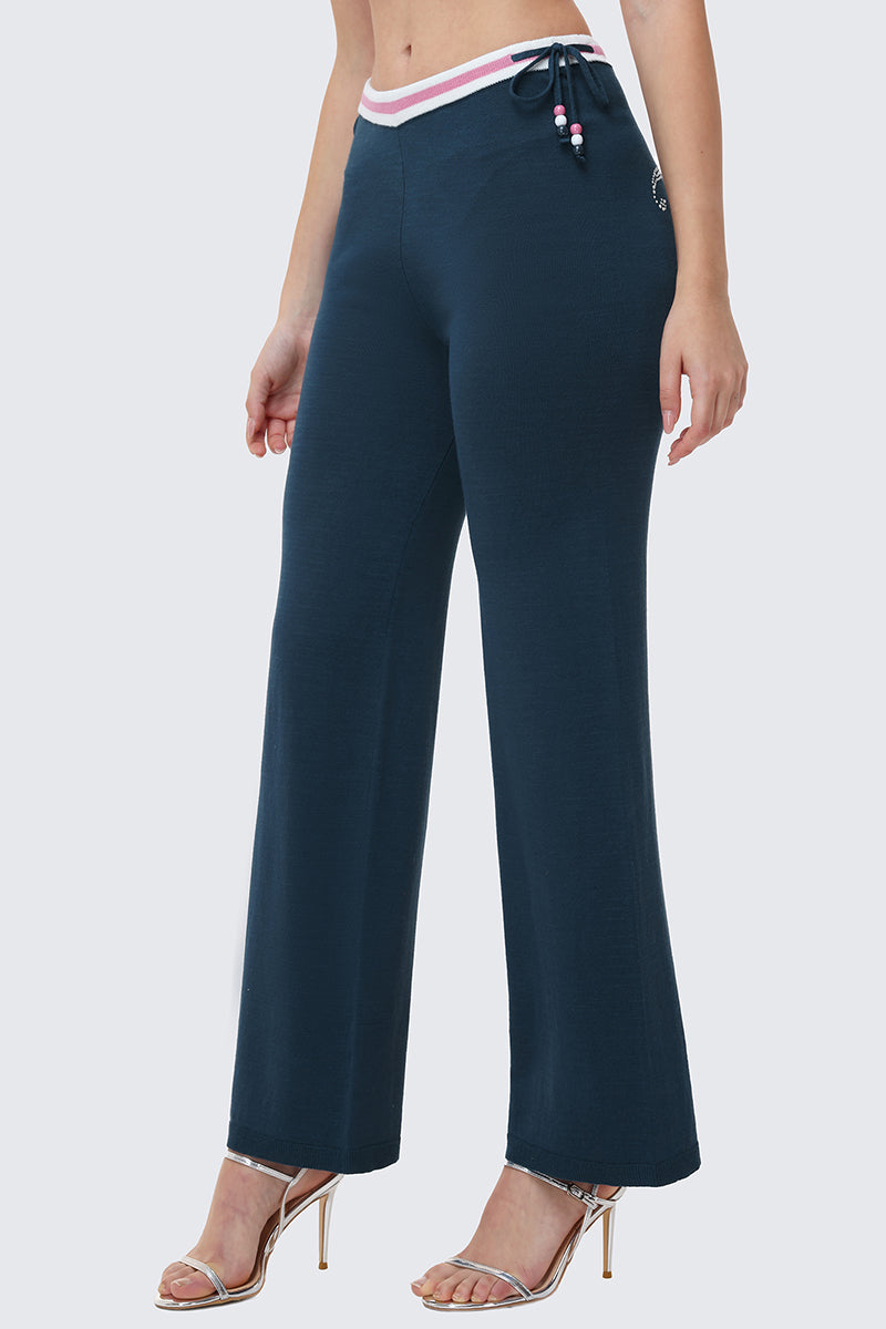 Someone stands against a light background wearing Big Bling Wide Leg Pants in navy blue, featuring ribbed wide legs, a contrast striped waistband, beaded drawstring, and silver high-heeled sandals.