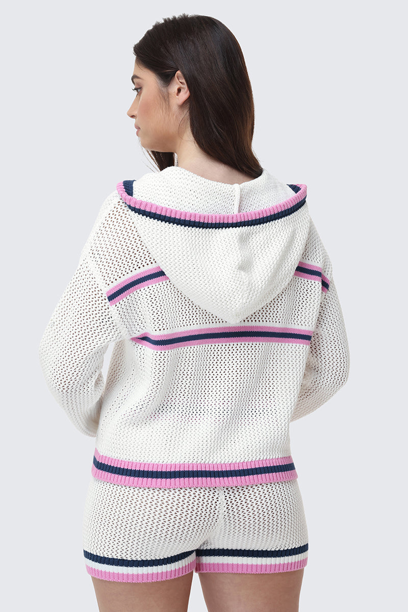 A woman with long brown hair is seen from the back wearing the Mesh Zip-Up Hoodie and matching shorts, both featuring pink and navy blue stripes, against a plain gray background.