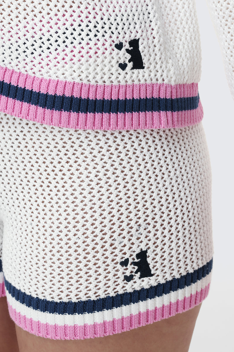 Close-up of a person wearing the Mesh Zip-Up Hoodie and matching shorts set, both with pink, navy, and white striped trim and a small black dog silhouette logo for a sporty yet stylish look.