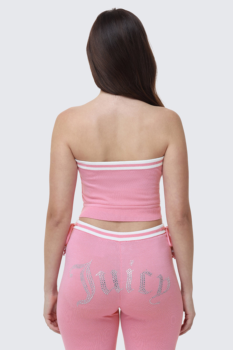 A woman with long brown hair is seen from behind wearing the pink Big Bling Tube Top and matching pants with "Juicy" in rhinestones across the back.
