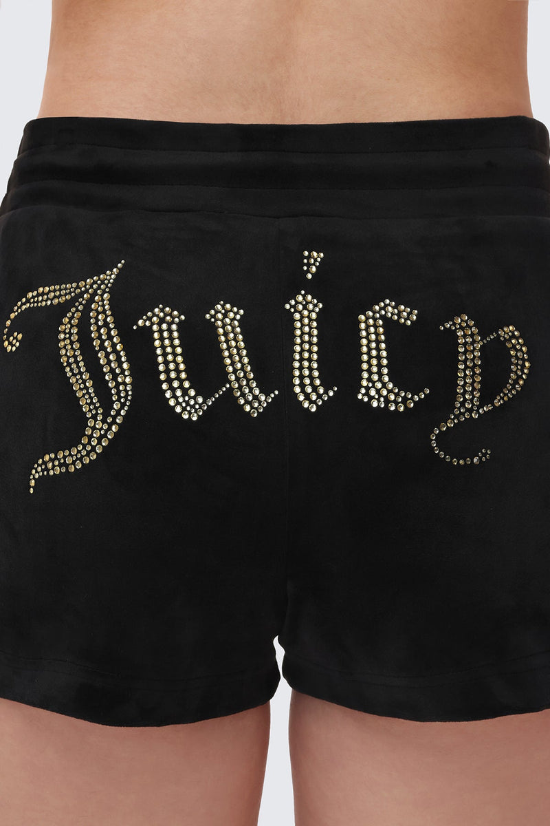 A close-up of a person wearing the Big Bling Velour Shorts, featuring a comfy drawstring waist and a rhinestone Juicy logo across the back.