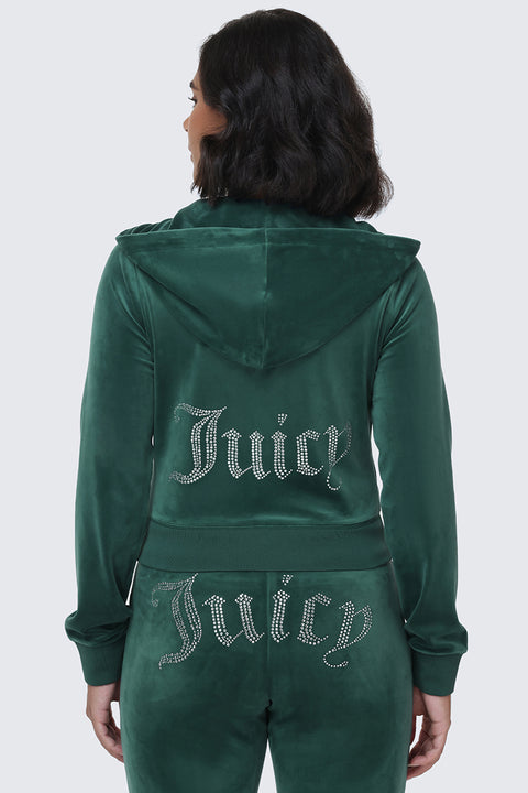 A woman with shoulder-length dark hair is seen from behind wearing the OG Big Bling Velour Hoodie in green, its back adorned with a rhinestone Juicy logo that perfectly channels the iconic Y2K vibe.