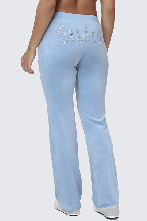 Seen from behind against a plain background, a person is wearing OG Big Bling Velour Track Pants in light blue, featuring sparkling “Juicy” rhinestone embellishment on the back for an authentic Y2K look.