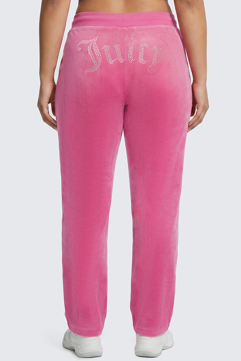 A person wearing Plus-Size OG Big Bling Velour Track Pants in bright pink, featuring the word “Juicy” in rhinestones on the back, stands with their back to the camera.