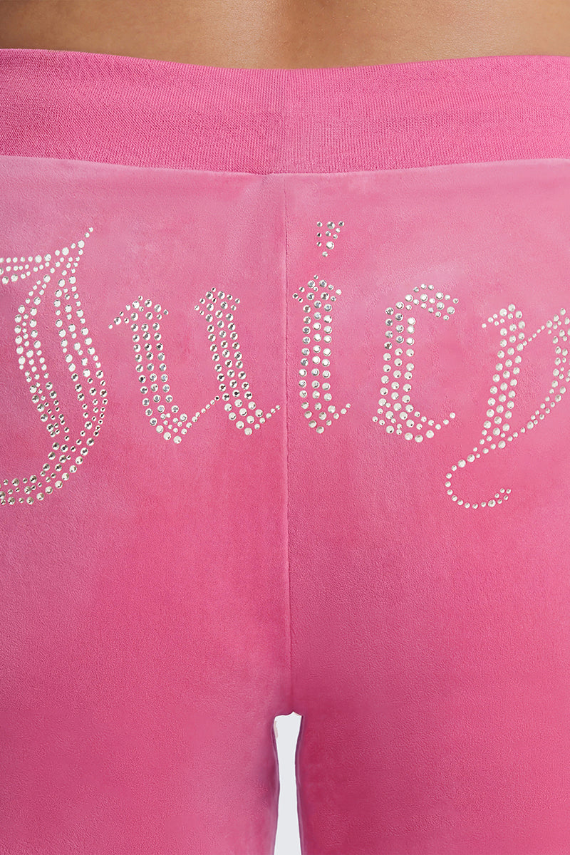Close-up of a person wearing the Plus-Size OG Big Bling Velour Track Pants in bright pink, featuring “Juicy” spelled out in rhinestones across the back for that iconic Y2K vibe.