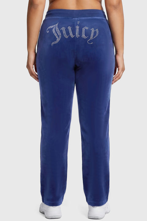 Plus-size model wearing OG Big Bling Velour Track Pants in blue, featuring “Juicy” in rhinestones across the back, standing against a neutral background and shown from behind.