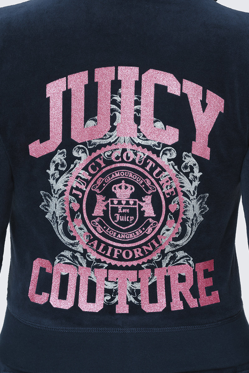 The back of the Scottie Cotton Velour Hoodie features navy blue cotton velour fabric with pink glittery "JUICY COUTURE" text and a central circular Scottie crest adorned with ornate detailing and the phrases "GLAMOUROUS JUICY COUTURE CALIFORNIA LOS ANGELES.