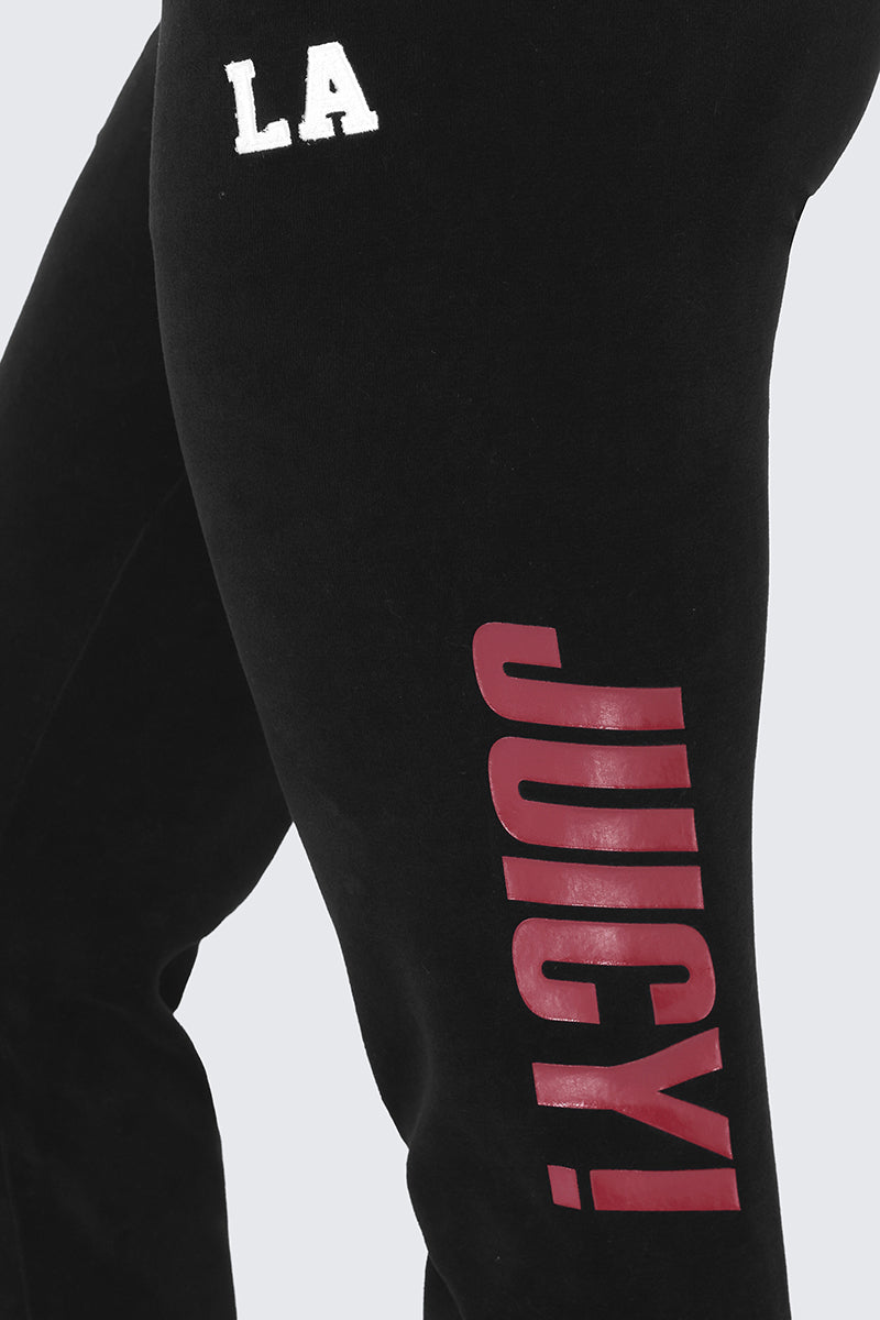 Close-up of the Mixed Logo Cotton Velour Jogger in black, featuring "LA" in white on the left hip and bold red "JUICY!" text printed vertically along the left thigh—a truly sporty staple.