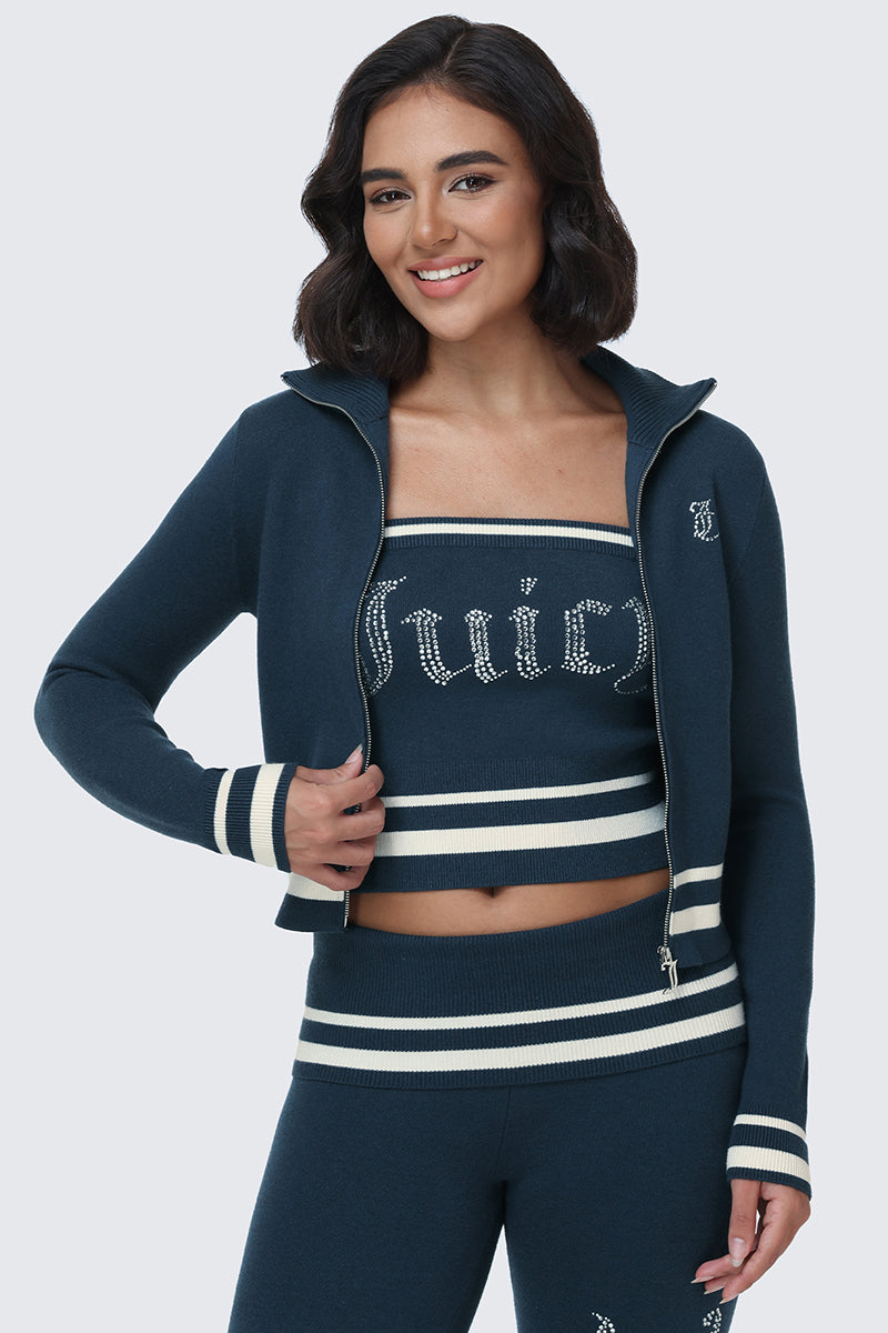 A woman models the Big Bling Tube Top—a navy blue piece featuring white stripes and a sparkling rhinestone logo—smiling with her hand on her hip against a plain background.
