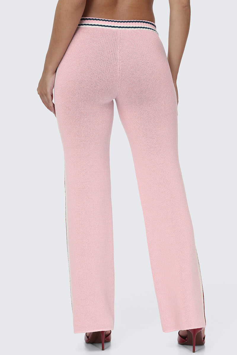 A person is shown from the back against a plain background wearing the Contrast Knit Wide Leg Pants, featuring a high-waisted, light pink textured knit design with wide legs and a striped waistband, paired with high heels.