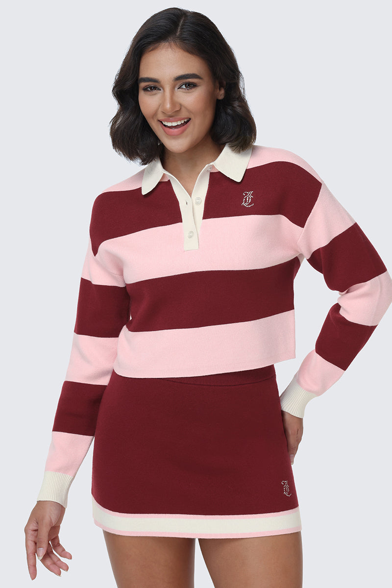 A woman smiles while wearing the Small Bling Knit Cropped Polo, a maroon and light pink striped knit top with a cropped silhouette, paired with a matching maroon skirt featuring cream trim.