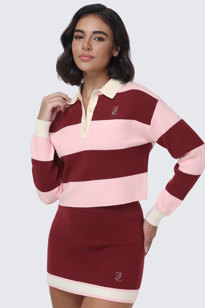 A woman wearing the Small Bling Knit Cropped Polo in maroon and pink stripes, styled with a matching maroon mini skirt featuring cream trim, stands against a light gray background.