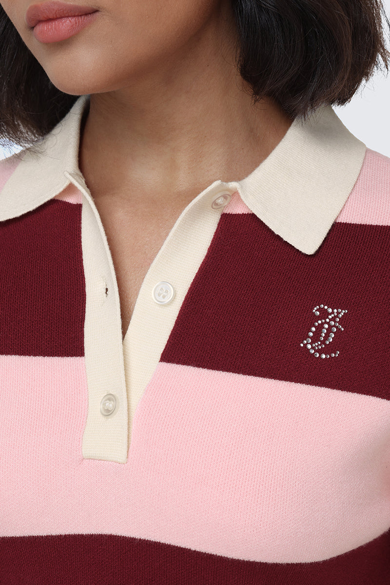 A woman is wearing the Small Bling Knit Cropped Polo, which features maroon and light pink stripes, a cropped silhouette, and a rhinestone letter T logo on the left chest. Only her lower face, neck, and upper torso are visible.
