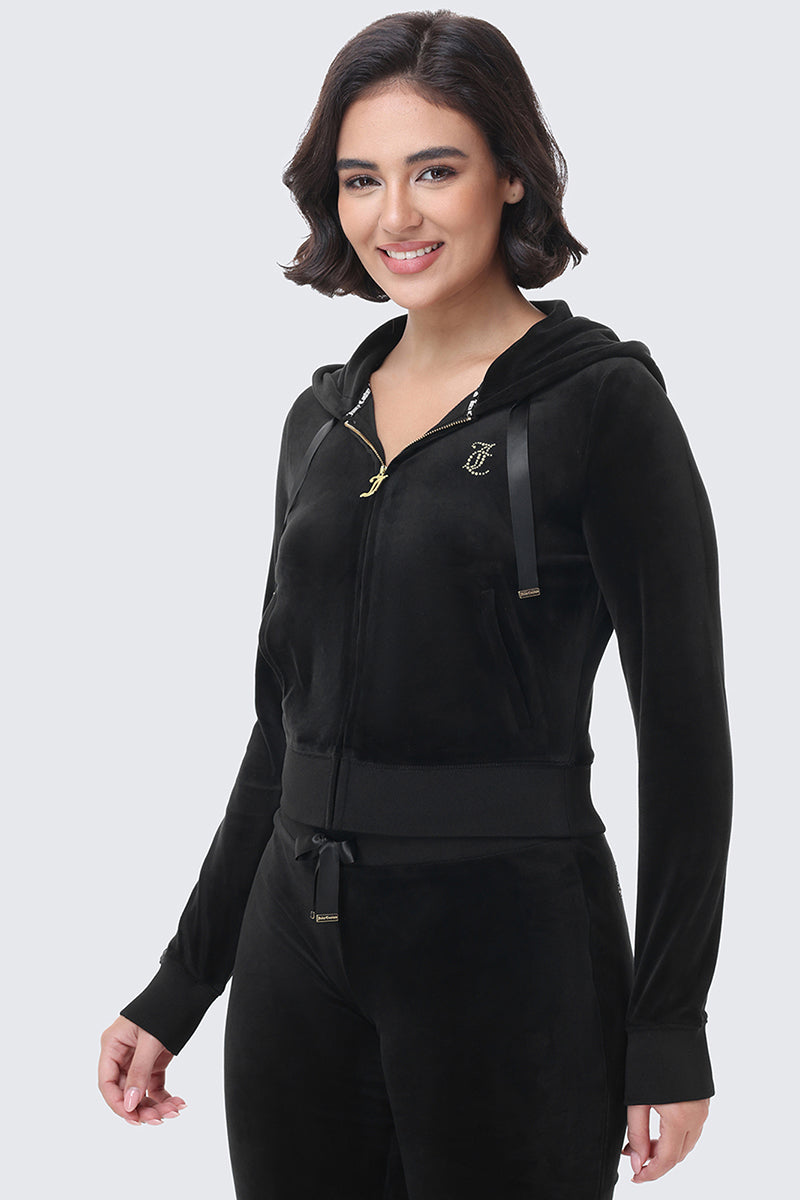 A woman wearing an OG Big Bling Ribbon Hoodie, a fitted athletic-style black zip-up hooded jacket with rhinestone details on the chest and ribbon drawstring ties.