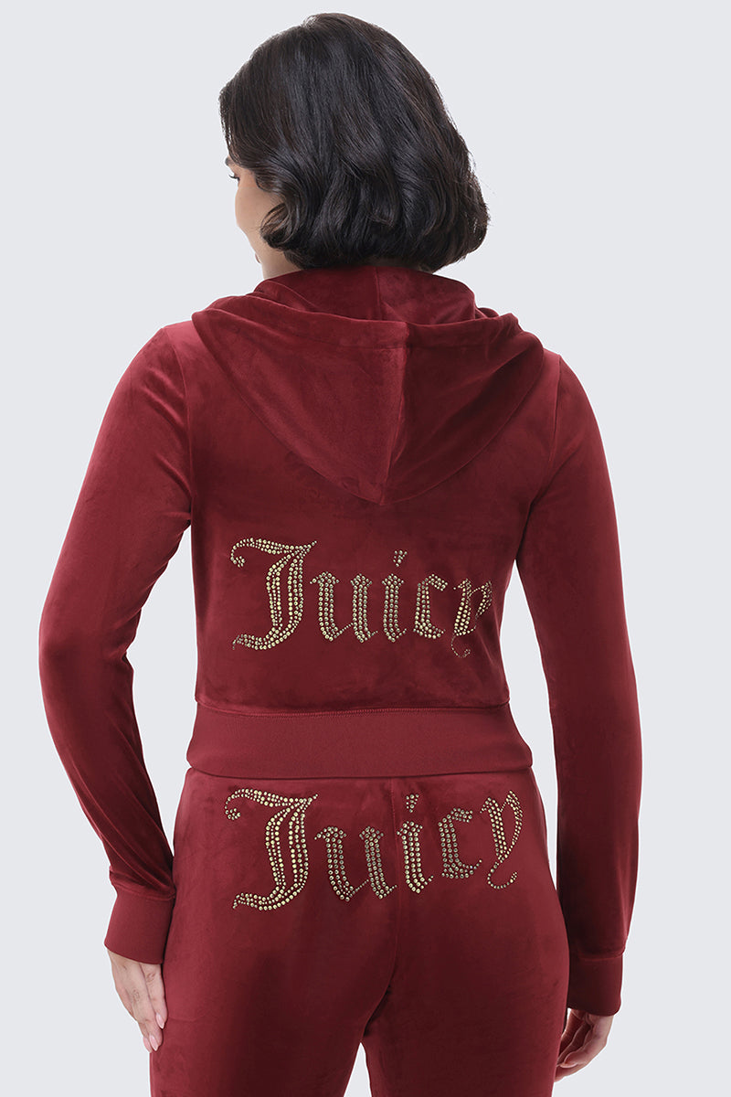 Back view of a person wearing an OG Big Bling Ribbon Hoodie and matching pants in maroon velour, both featuring the word Juicy spelled out in gold rhinestones.