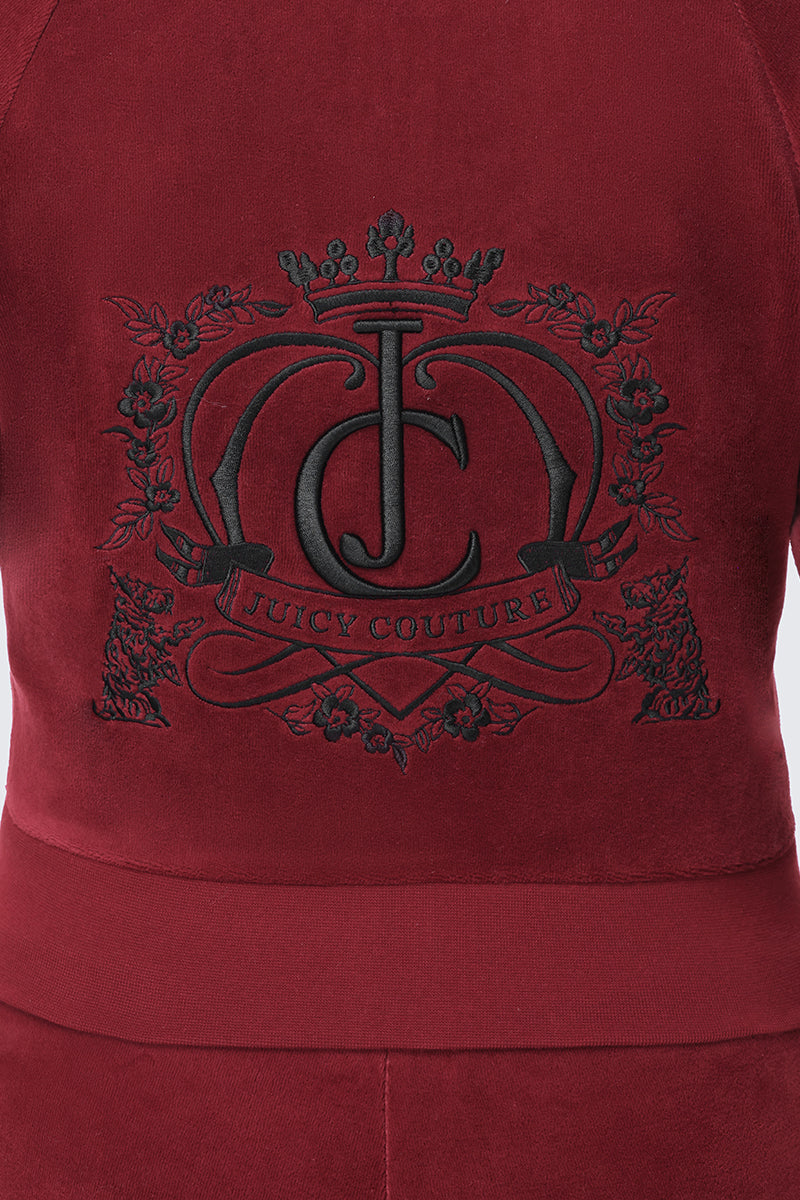Scottie Crown Cotton Velour Jacket in dark red, featuring a large black embroidered crest with a central JC logo and the text JUICY COUTURE on a banner.