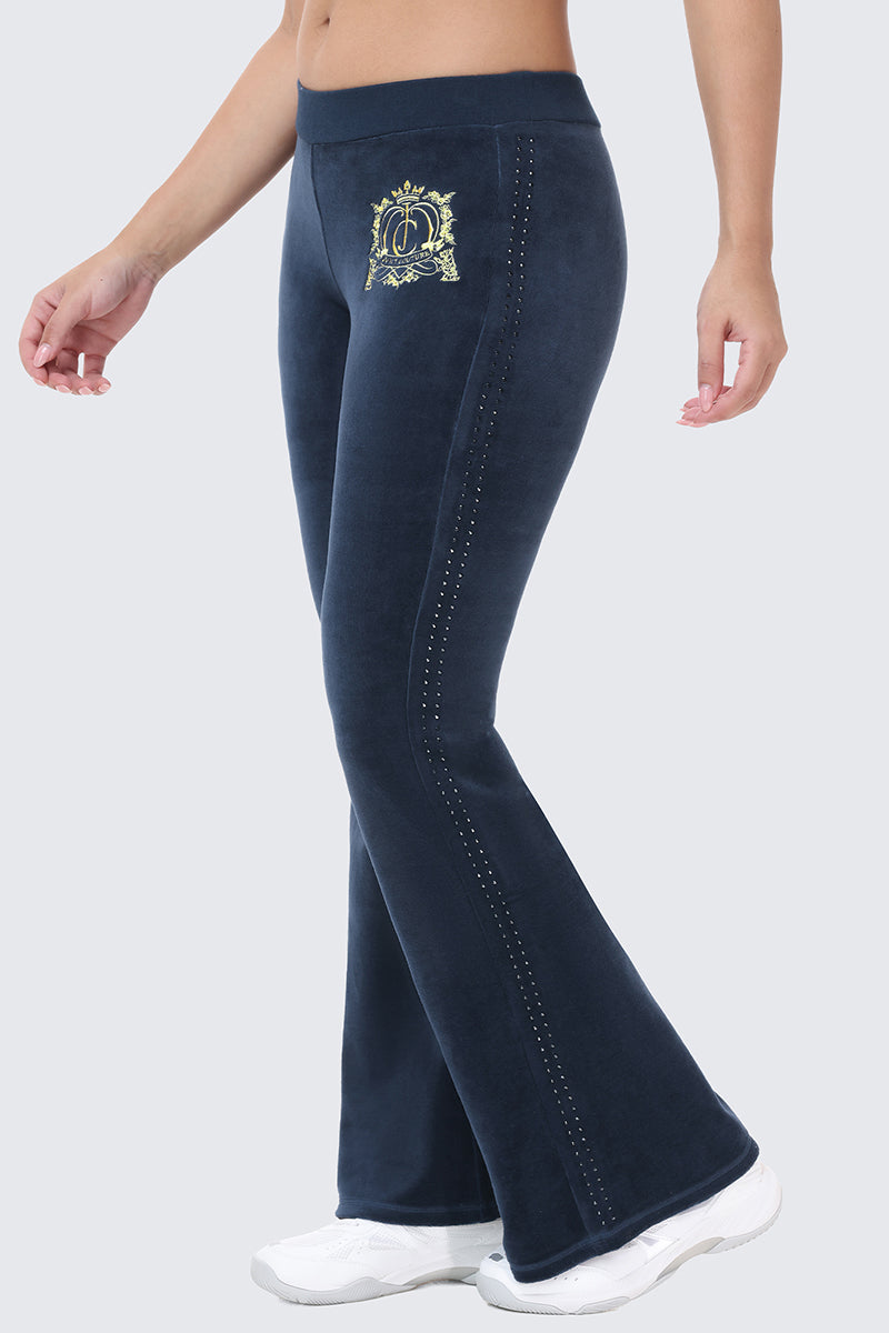 Scottie Crown Cotton Velour Track Pants in navy blue, featuring a gold embroidered crest at the hip and a vertical row of studs along the side seams.