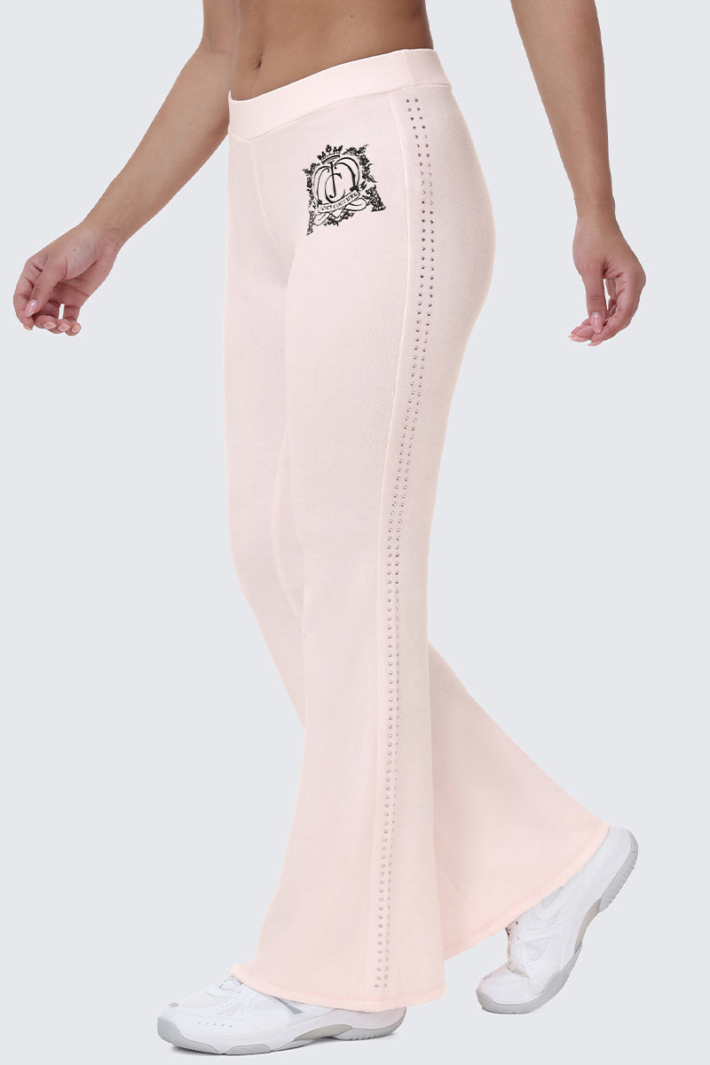 Light pink Scottie Crown Cotton Velour Track Pants with a flared, sporty silhouette, featuring a black embroidered crest on the hip and a vertical line of rhinestones down the side.