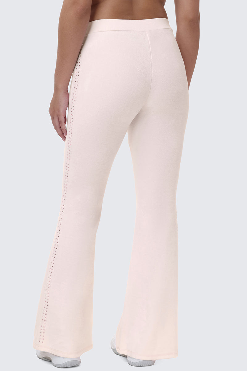 Back view of pale pink Scottie Crown Cotton Velour Track Pants with a flared fit and perforated trim down the sides.