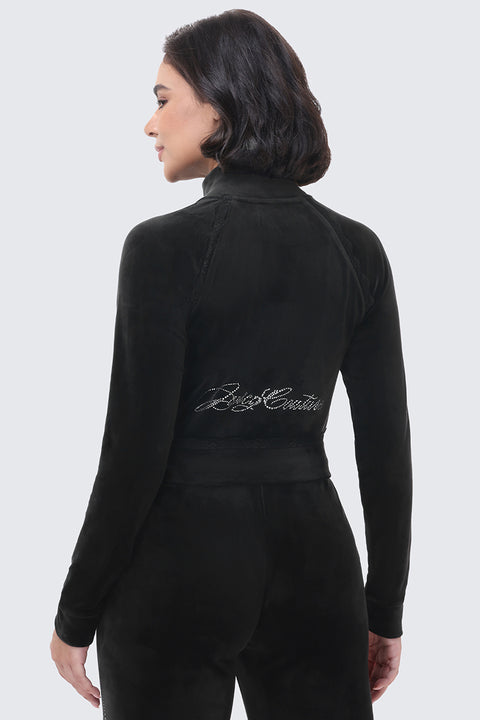 Back view of a person wearing a black velour Small Bling Velour Jacket with script text spelled out in rhinestones across the lower back.