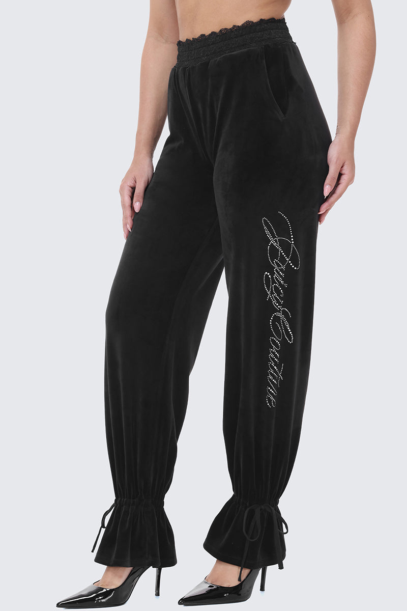 Black Small Bling Velour Track Pants with a lace-trimmed waistband, rhinestone lettering on the left leg, and drawstring cinched ankles.
