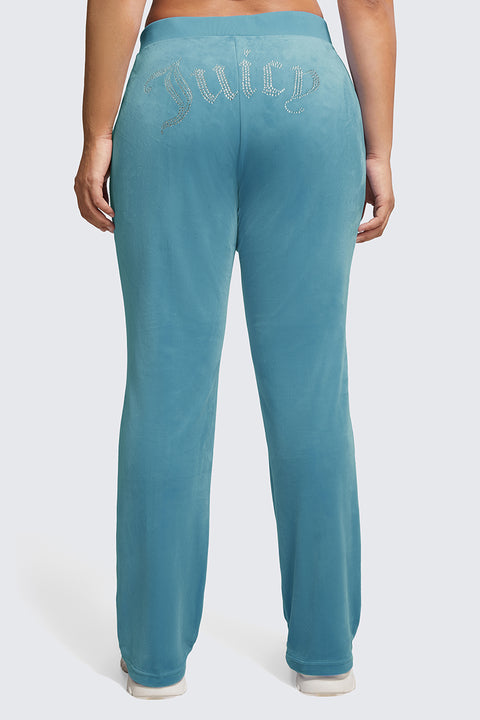 A person shown from behind wears Plus-Size OG Big Bling Velour Track Pants in teal, featuring "Juicy" spelled out in rhinestones across the back.