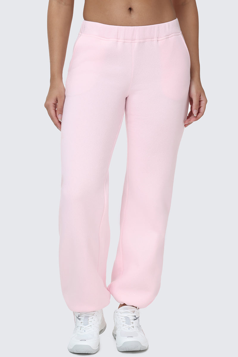 A person is shown from the waist down wearing Embroidered Knit Bubble Leg Pants in light pink paired with white sneakers, standing against a plain light gray background.