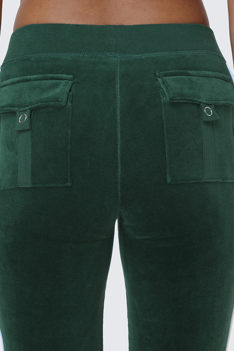 Close-up of the back of a person wearing Cotton Velour Track Pants in dark green, featuring two flap back pockets with silver button details.