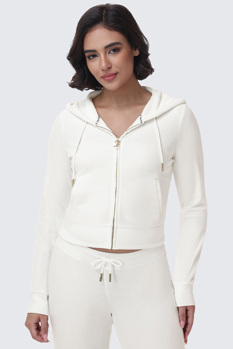 A person wears a white OG Big Bling Velour Hoodie with a gold-toned zipper pull and a rhinestone logo.