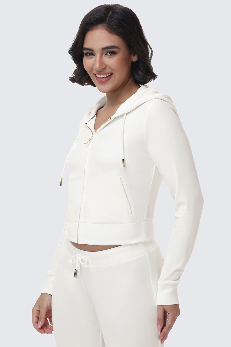 A person wearing a white OG Big Bling Velour Hoodie with a rhinestone logo.