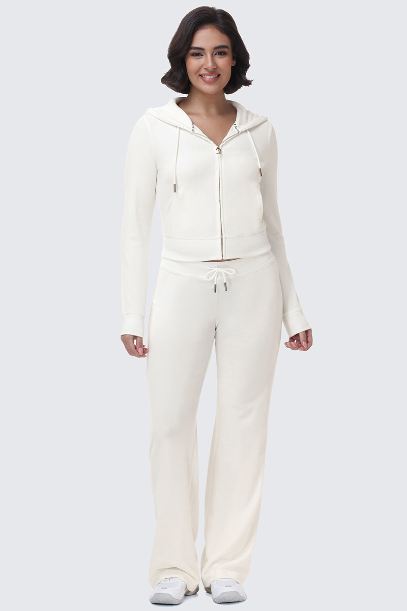 A person wearing a matching cream-colored OG Big Bling Velour Hoodie with a rhinestone logo and drawstring pants.