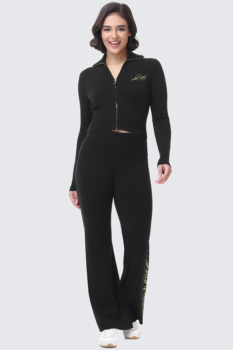 A person wearing a black Embroidered Knit Cropped Jacket and matching flared pants.