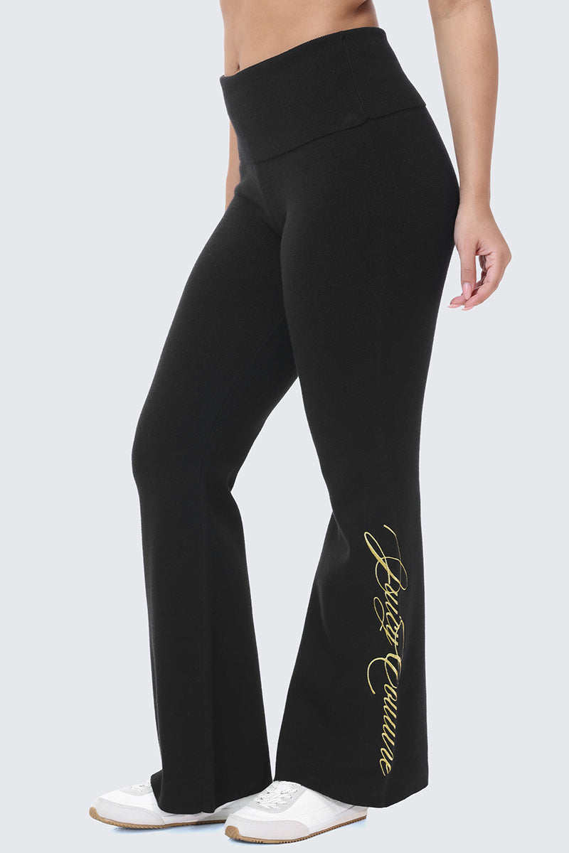 Embroidered Knit Flare Pants in black, featuring a fold-over waistband and gold embroidered script text on the lower leg.