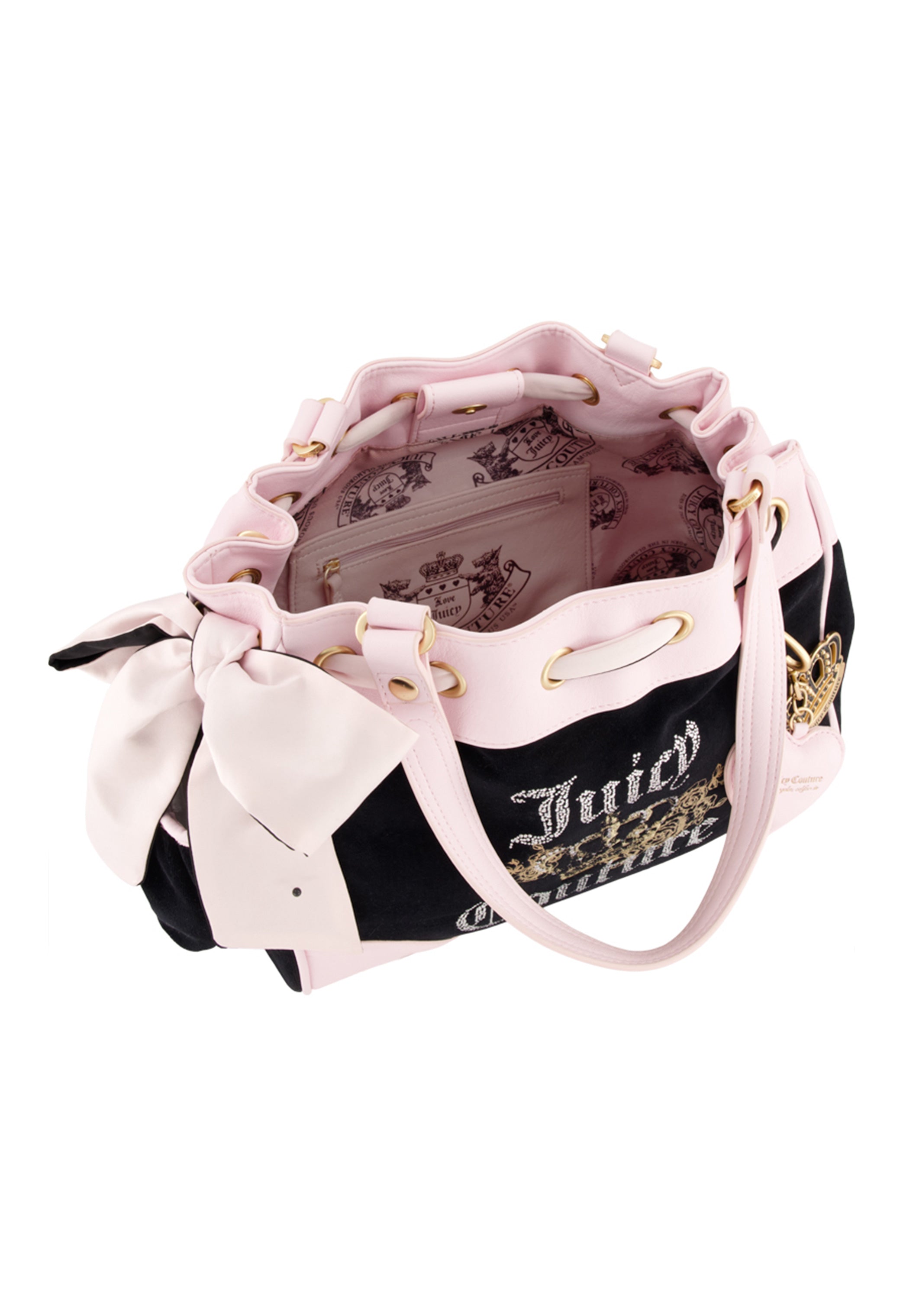 The Royal Bloom Daydreamer Tote Bag by Juicy Couture features pink and black colors, gold accents, a large white bow on the handle, a drawstring opening, and a spacious light pink interior with crown and crest patterns for added glamour.