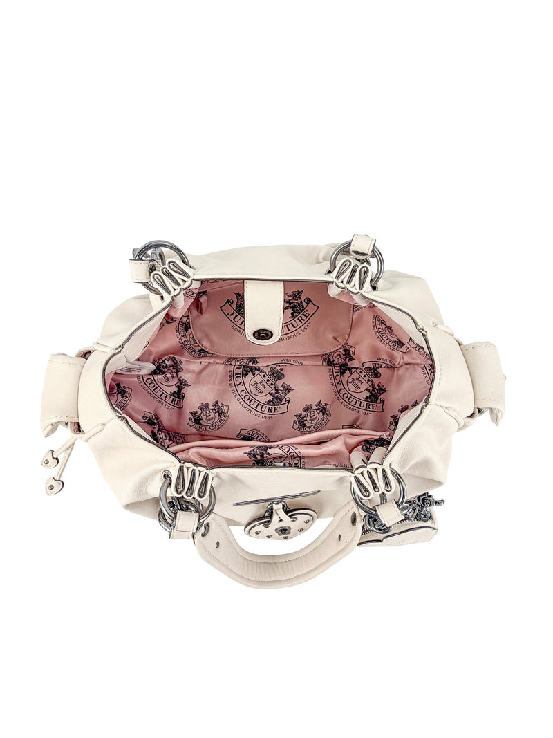 The Vintage Vibes Satchel Bag features a cream exterior, silver hardware, and an open view of its pink satin lining with a Juicy logo print—ideal for fans of retro glamour.