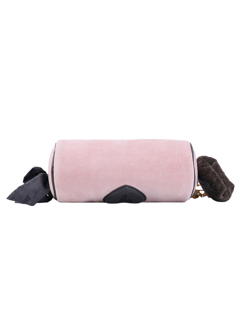 Crowns & Kisses shoulder bag in cylindrical pink with dark trim, a decorative ribbon, and a small dark quilted pouch featuring Juicy details attached to the gold chain strap.