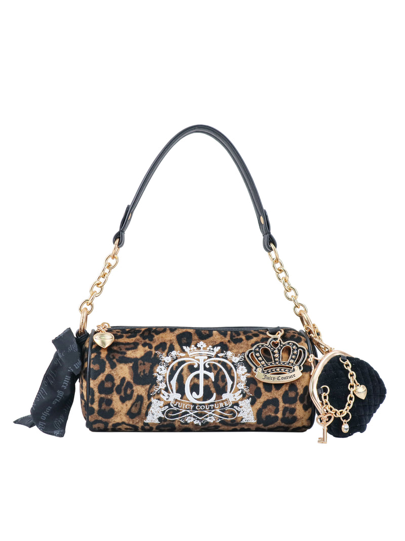 The Crowns & Kisses Shoulder Bag is a cylindrical leopard-print bag with a white logo crest, a crown motif, black accents, a shoulder strap, a decorative ribbon, and a pom-pom charm that evokes feminine nostalgia.