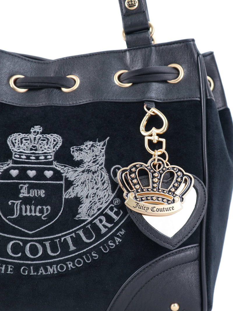 Scottie Heritage Daydreamer tote bag in black polished leather with a drawstring top, embroidered Scottie motif, and a hanging gold-tone crown charm.