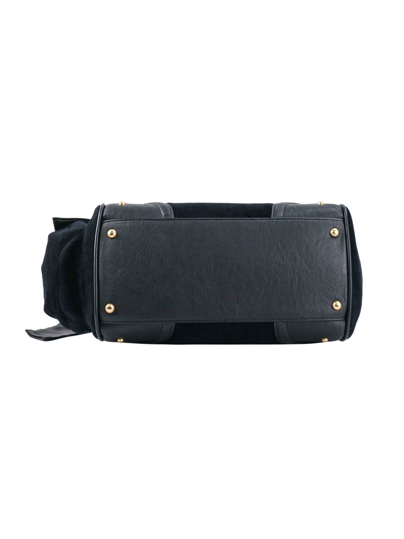 Bottom view of a black, polished Scottie Heritage Daydreamer Tote Bag featuring four gold-tone metal feet and a Juicy charm.