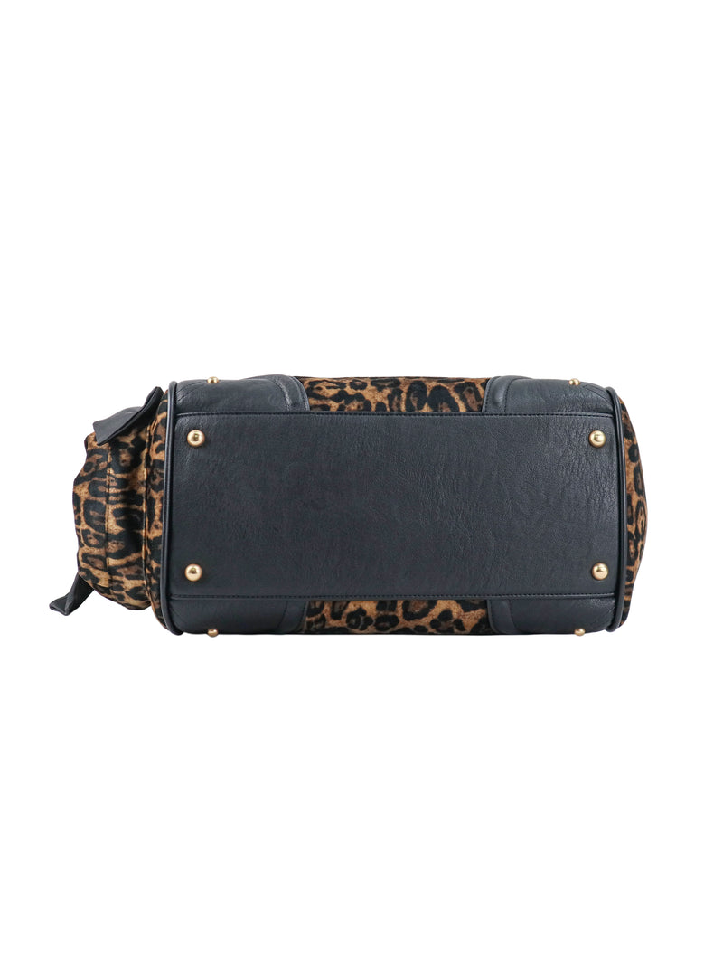 Bottom view of a Scottie Heritage Daydreamer Tote Bag, featuring a polished black and leopard-print exterior, a Scottie motif, and gold-tone metal feet.
