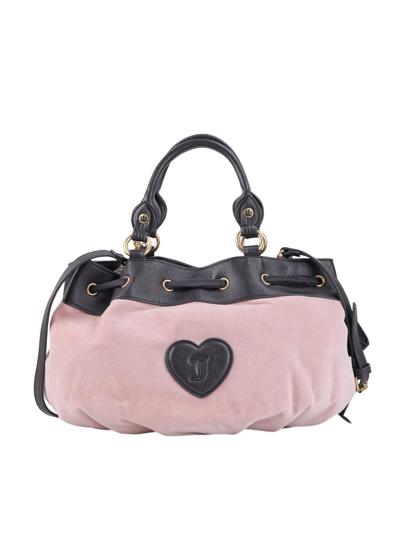 Crowns & Kisses Satchel Bag in light pink with a black leather top, handles, and a central heart-shaped patch featuring an embossed letter J.