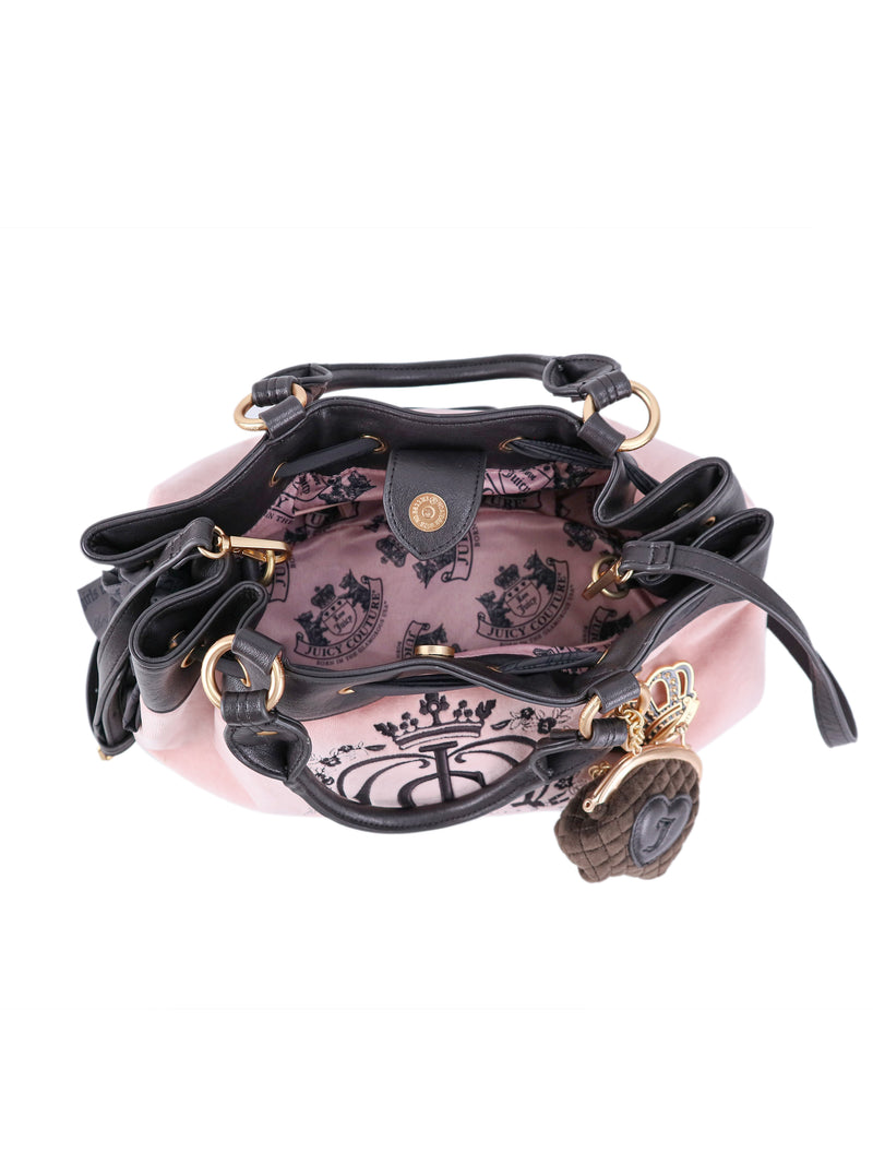Top-down view of a pink Crowns & Kisses Satchel Bag with dark handles and a dangling heart-shaped charm, featuring a pink interior lining with a black crown logo print.