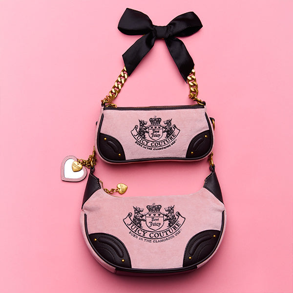 Pink handbag with black accents and Juicy Couture logo on a pink background