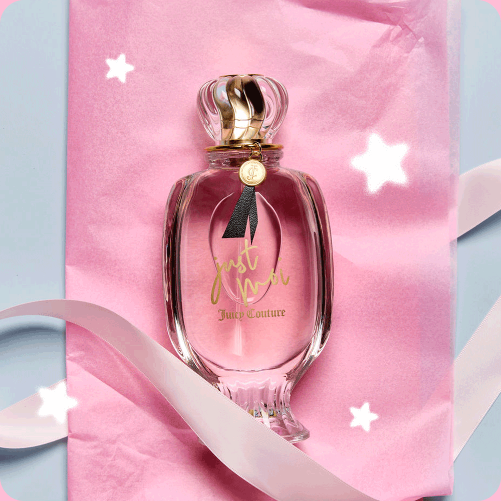 GIF of a shot of a perfume bottle with text "Just Moi Juicy Couture" laid on top of pink wrapping paper and a white ribbon, with white stars rotating above.